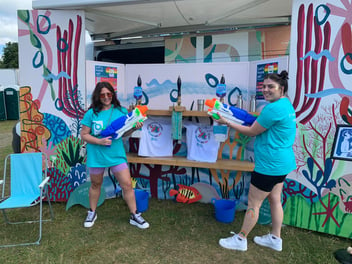 two Bristol Water volunteers with water pistols at the Water Bar during Bristol Pride