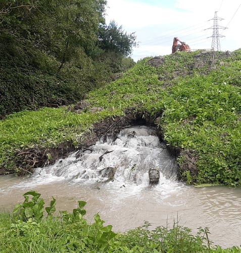 Water pouring out of a hole in the ground