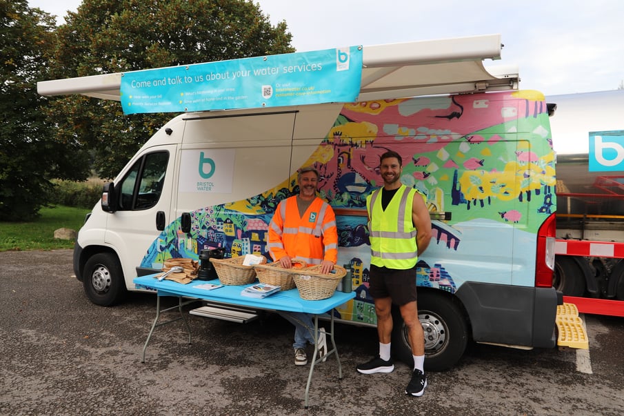 Two colleagues stood next to a Bristol Water event van.