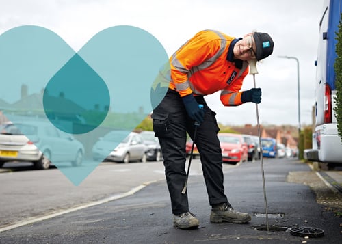 A Bristol Water engineer listens to a drain to check for leaks