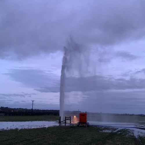 A burst water mains shoots water into the air