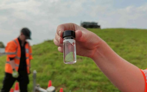 A Bristol Water employee holds up a sample of clear water following flushing