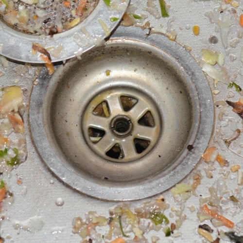 Food debris and waste around a sink drain