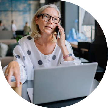 Woman making a phone call whilst at her desk