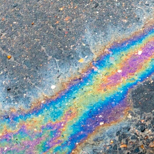 Oil spill in a puddle on the road