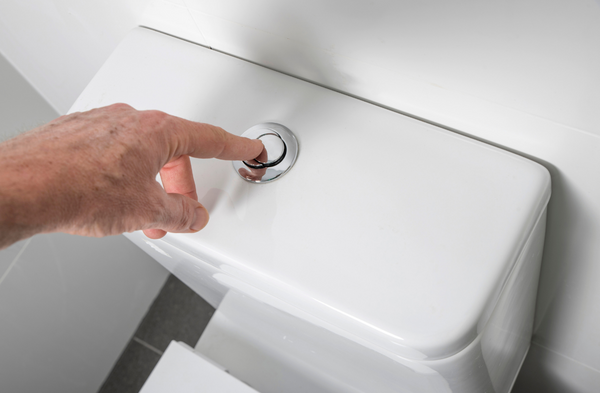 white hand flushing a toilet