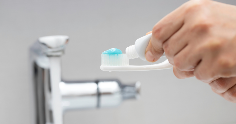 applying toothpaste to a toothbrush