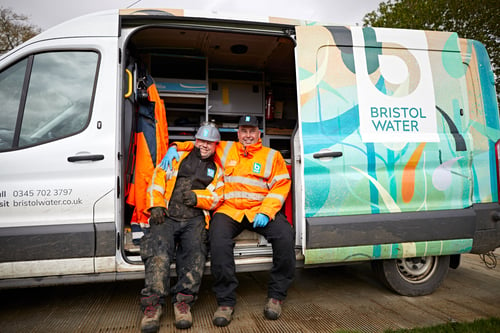 Two men in high visibility jackets sitting in a Bristol Water van