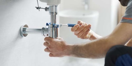plumber_fixing_a_sink_to_a_wall