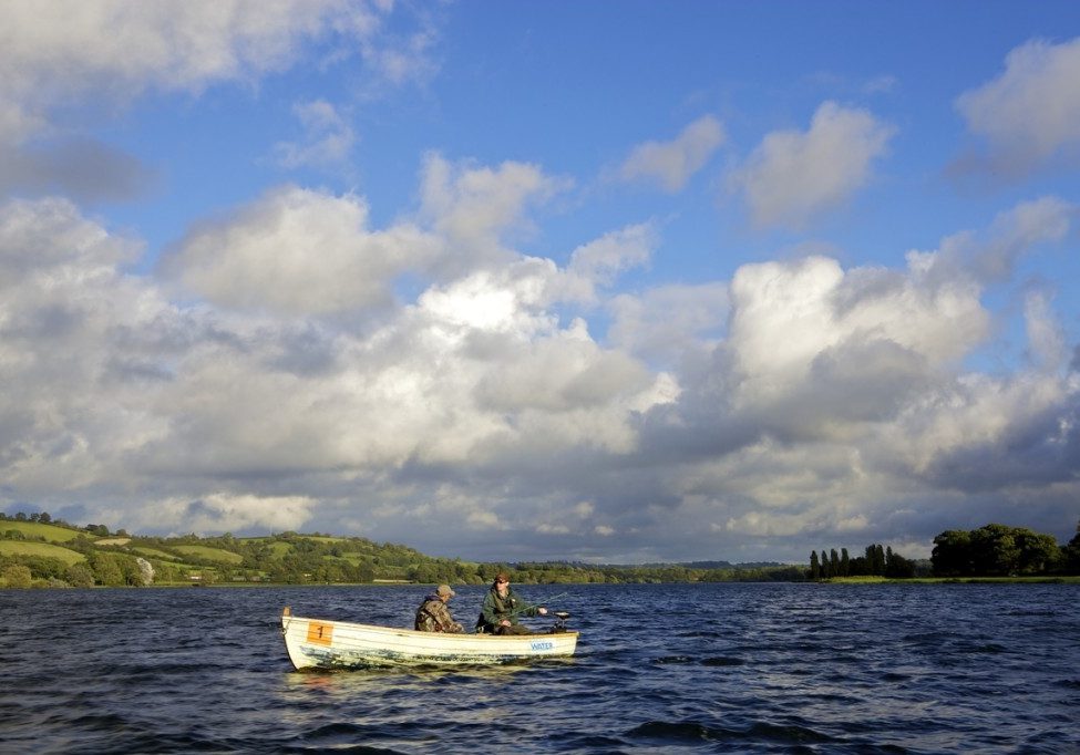 Two men fishing in Blagdon Lake in a small white boat