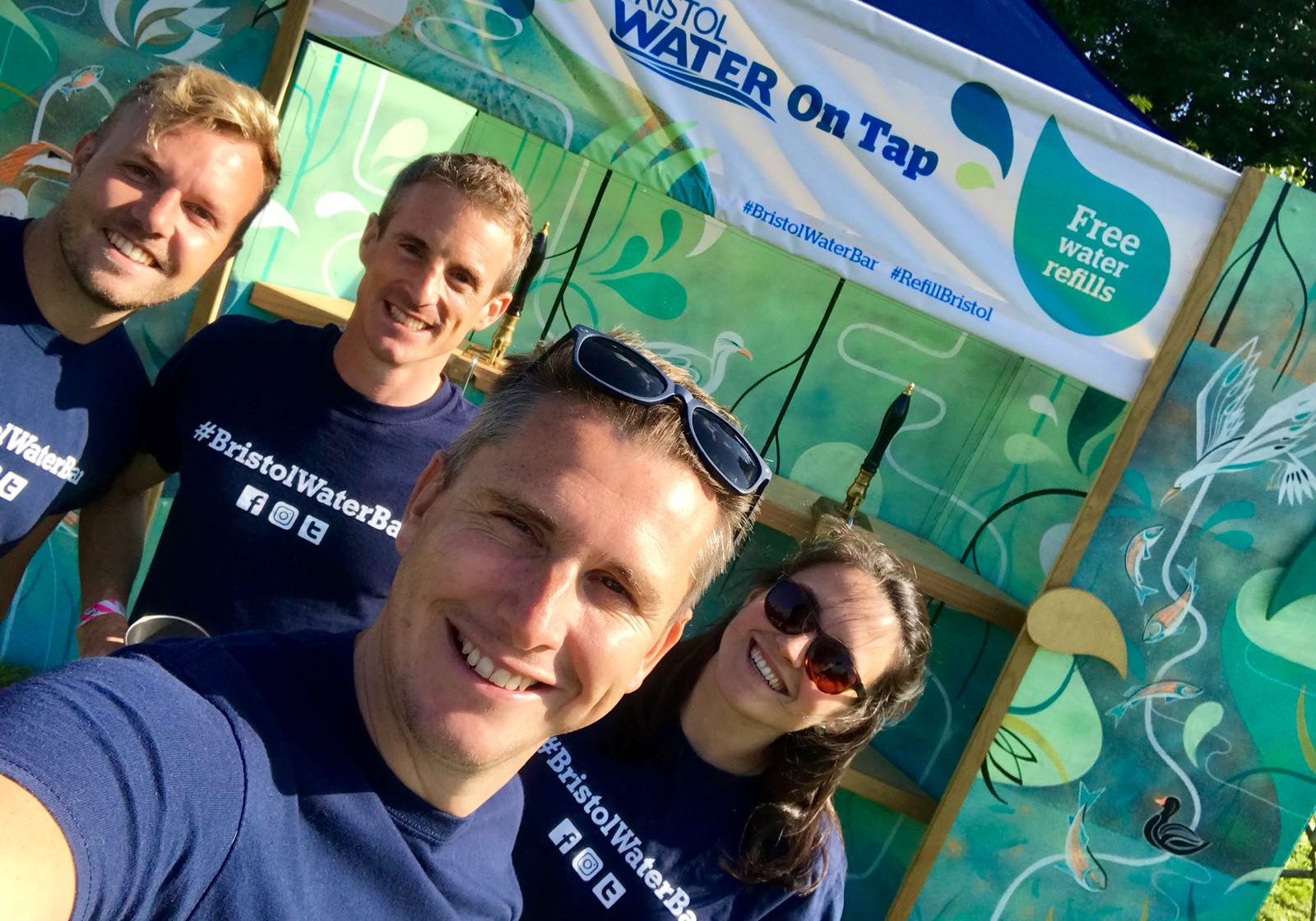 Four Bristol Water Workers in front of the free water bar at a festival 