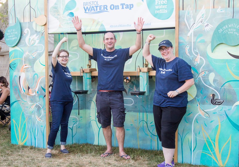 Three Bristol Water workers manning the free water bar at a festival 
