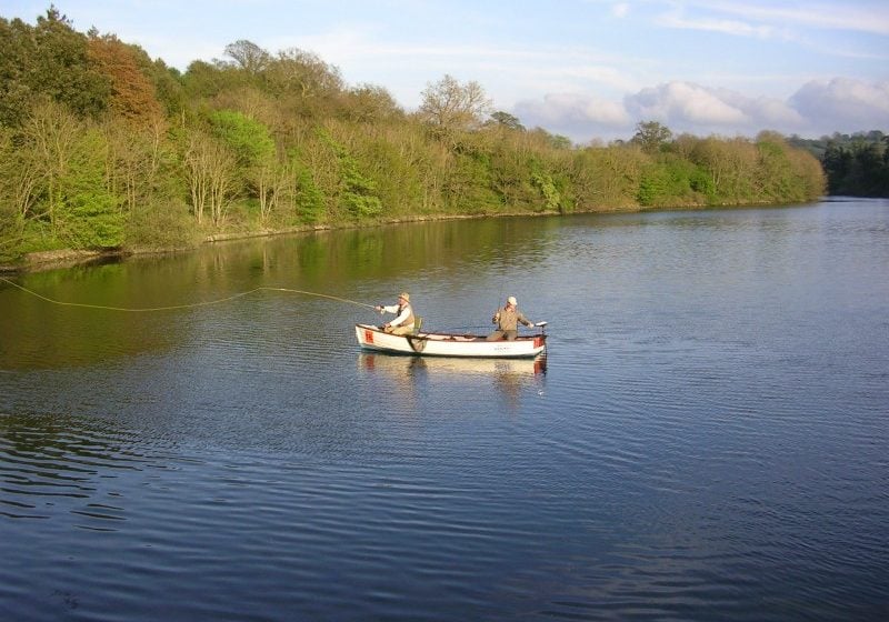 Two men fishing in a small white boat in Litton Lake