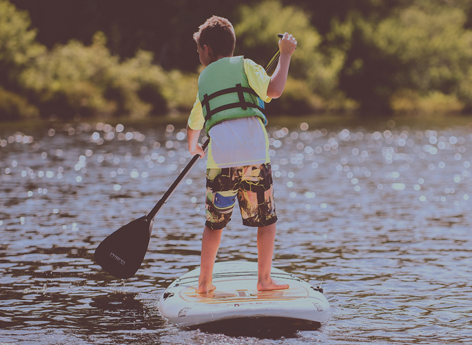 Boy paddle boarding on cheddar reservoir